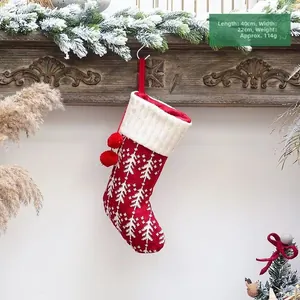 Detail van rode gebreide kerstsok met witte boompjes en afmetingen van 40x22cm