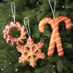 Close-up of gingerbread style wreath and snowflake ornaments on a festive Christmas tree