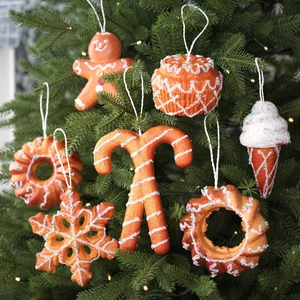Close-up of assorted Christmas gingerbread man and cupcake ornaments on a pine tree