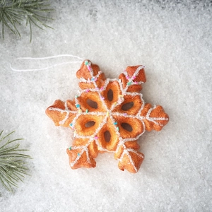 Detailed close-up of a gingerbread snowflake ornament with icing texture and glitter