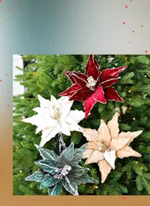 Close-up of sparkling poinsettia ornaments with glitter on a lit Christmas tree