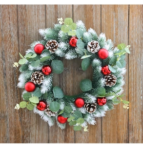 Detail of Christmas wreath with eucalyptus leaves, red baubles, and natural pine cones
