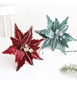 Detailed view of red and green velvet poinsettia flowers with gold glitter accents