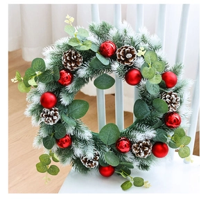 Detail of Christmas wreath with eucalyptus, pine cones, and red balls on a wooden chair