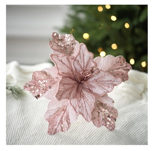 Detail of pink velvet artificial poinsettia with glitters on a soft knit background