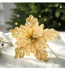 Sparkling gold artificial poinsettia with sequins on white knit fabric background