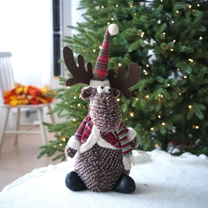 Close-up of a sitting Christmas reindeer doll with red plaid jacket and soft brown fur