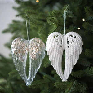 Glitter acrylic angel wing ornaments hanging on Christmas tree branches, set of two