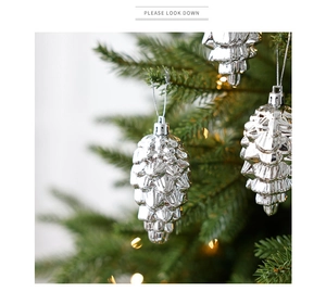 Close-up of metallic silver pinecone ornament hanging on a festive Christmas tree branch