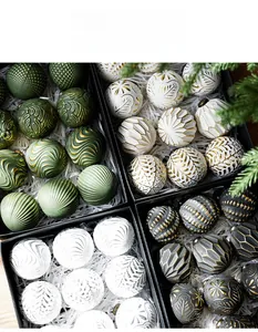 Détail de boules de Noël vintage avec motifs dorés en relief dans une boîte cadeau