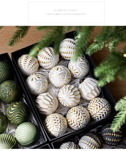 Vue détaillée de boules de Noël vintage avec textures dorées en relief dans une boîte cadeau
