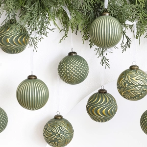Lot de 12 boules de Noël vintage vert sauge et or suspendues sur des branches de pin
