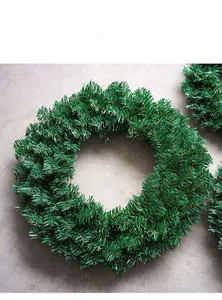 Detailed macro view of dense green PVC artificial pine needle Christmas wreath on grey surface
