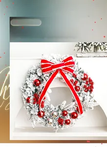 Macro detail of Christmas wreath with snowy branches, red velvet bow and ornaments