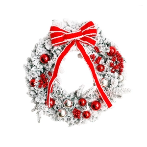 Christmas wreath with flocked snow pine needles, red bow and berries on white background