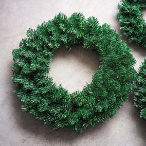 Lush green PVC artificial Christmas wreath for festive DIY decoration on grey background