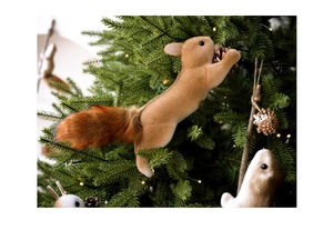Detail eines flauschigen Eichhörnchen-Ornaments mit Zapfen am grünen Weihnachtsbaum