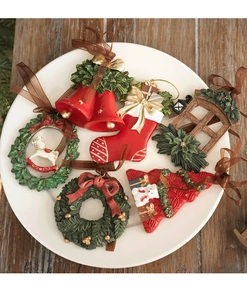 Close-up of assorted resin Christmas ornaments with stockings and wreaths in a white plate