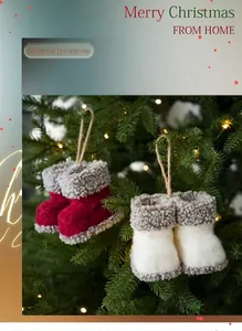 Detail van rood-witte kerstlaarzen van wolvilt die aan een verlichte boom hangen