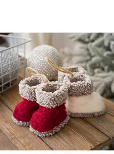 Detail van handgemaakte vilten kerstlaarzen met bontrand op een rustieke houten ondergrond