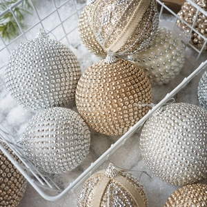 Elegant champagne and silver Christmas balls with pearls and rhinestones in a wire basket