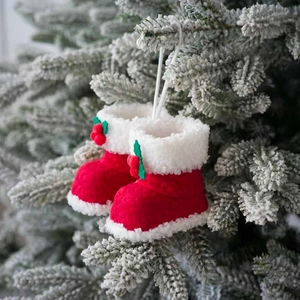 Rode gebreide kerstlaarsjes met wit imitatiebont en hulst aan de kerstboom hangend