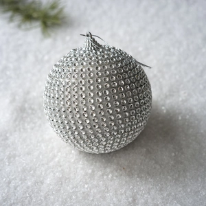 Champagne foam Christmas ball with sparkling silver rhinestones on a snowy background