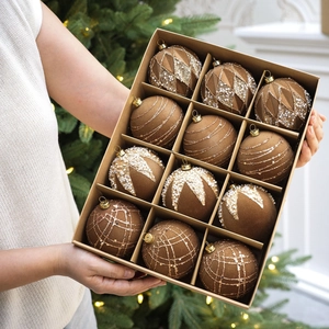 Détail de 12 boules de Noël floquées marron avec paillettes dorées tenues en main