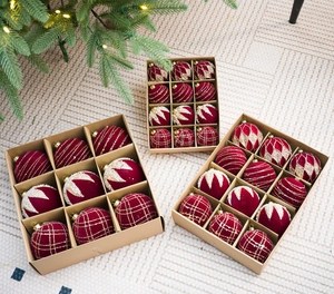 Gros plan de boules de Noël en velours rouge vin avec motifs pailletés dorés