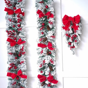 Christmas snowy flocked garland and swag with red berries, pine cones and velvet bows