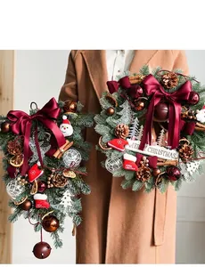 Detail of Christmas wreath with velvet bow, pine cones and small Santa ornament