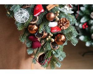 Close-up of artificial pine swag with pine cones and red Merry Christmas stockings