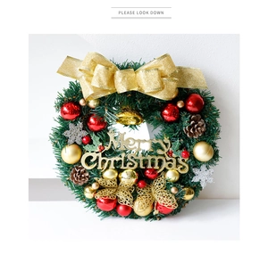 Détail de couronne de Noël avec nœud doré, boules rouges et signe Merry Christmas