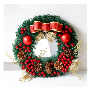 Détail d'une couronne de Noël avec nœud rouge, pommes de pin et baies rouges
