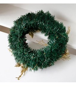 Détail d'une couronne de Noël avec aiguilles de pin vertes et feuilles dorées scintillantes