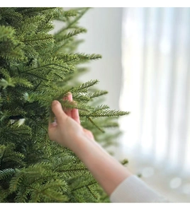 Close-up of high-density deep green realistic PE pine needles on a lush Christmas tree