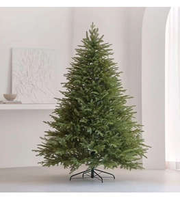 Detailed close-up of dense artificial PE needles and sturdy metal stand of the Christmas tree