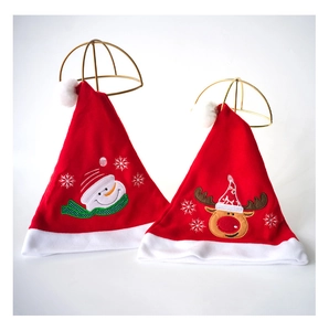 Detail of plush Christmas hats featuring reindeer and snowman embroidery with white fur trim