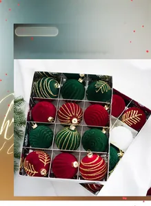 Close-up of red and green flocked Christmas balls with gold glitter patterns in a gift box