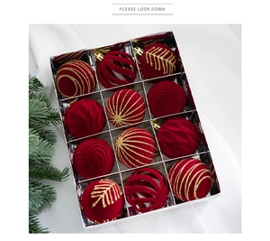 Detailed view of 12 red velvet Christmas balls with gold glitter in a silver box