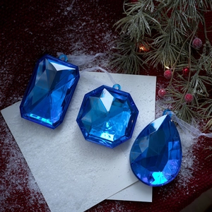 Juego de tres adornos navideños de gemas azules facetadas con cintas blancas