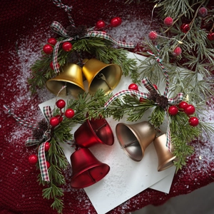 Christmas hanging bells with pine branches, red berries, and plaid bows for holiday decor