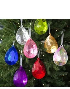 Facettierte Weihnachtskugeln in Tropfenform an einem festlich beleuchteten Baum