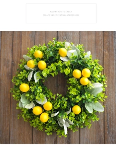 Detailed close-up of artificial lemon wreath with green leaves on rustic dark wood backdrop