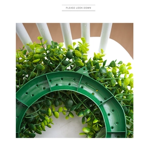 Detail of the green plastic ring support frame with hanging holes for lemon wreath