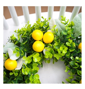 Detailed close-up of artificial lemon wreath with yellow fruits and green eucalyptus leaves