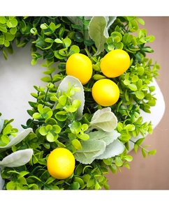 Close-up of artificial lemon wreath with yellow lemons and green eucalyptus leaves