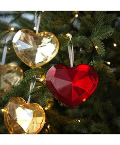 Faceted acrylic heart ornaments in red and gold with white ribbons on a Christmas tree