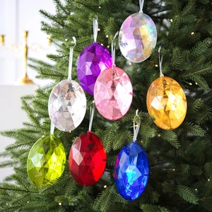 Adornos de gemas acrílicas coloridas en forma de huevo colgados en un árbol de Navidad