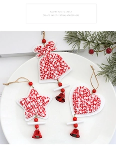 Detalle de tres adornos navideños con estrella, corazón y campana en tela roja rústica